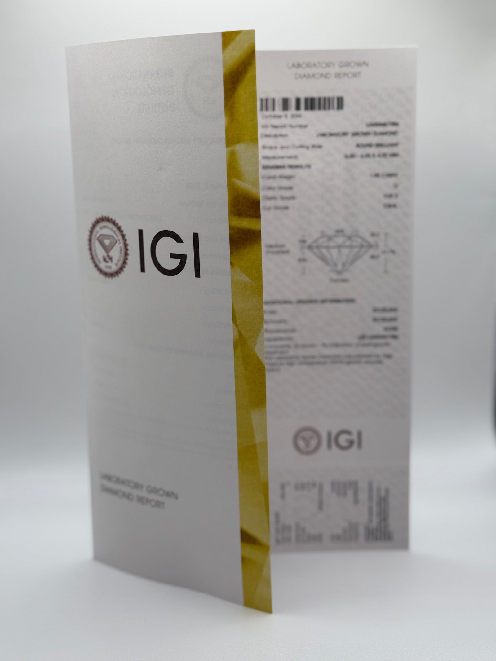 Photo of an IGI lab-grown diamond certification report standing upright, showing the IGI logo, grading details, and a gold vertical stripe along the right edge.